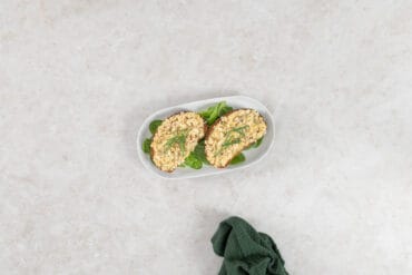 Veganer Thonsalat auf zwei Scheiben Ruchbrot mit Schnittlauch auf Salatblättern