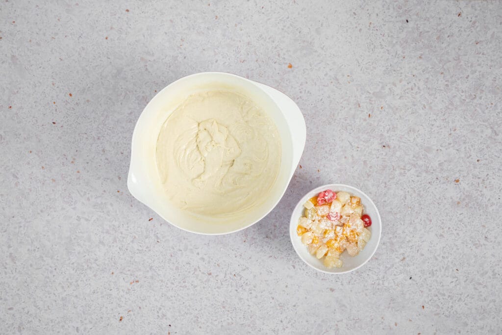 Fertiger Cake-Teig neben abgetropftem Fruchtsalat, der zum Wenden in Mehl gedreht wurde
