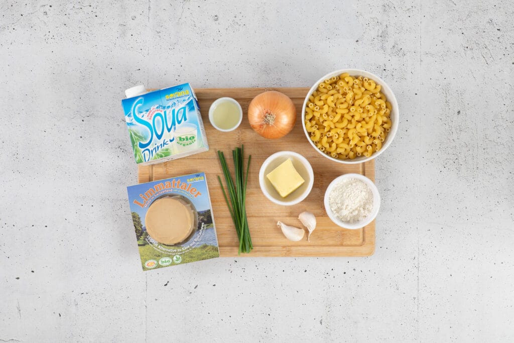 Zutaten für vegane Chäshörnli mit Hörnli, Limmattaler und Bio-Soya-Drink von Soyana, Zwiebel, Knoblauch, Schnittlauch und veganer Butter