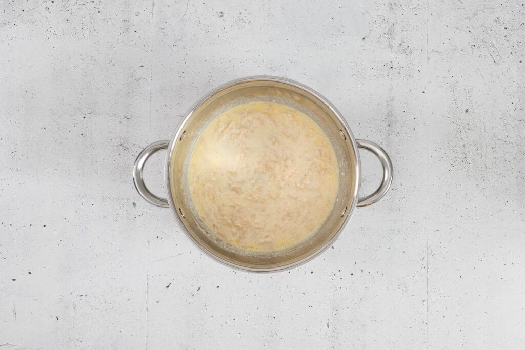 Geschmolzener veganer Käse ergibt im Topf eine cremige Käsesauce