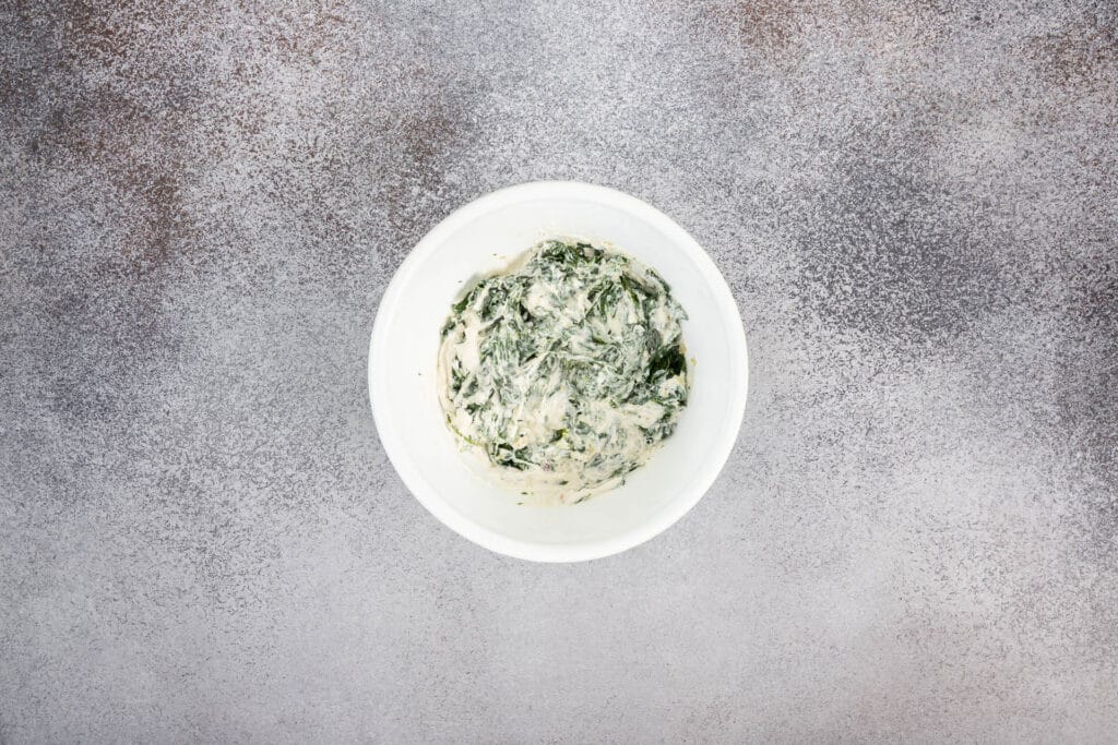 Cremige Spinat-Frischkäse-Füllung für vegane Conchiglioni in einer weissen Schüssel