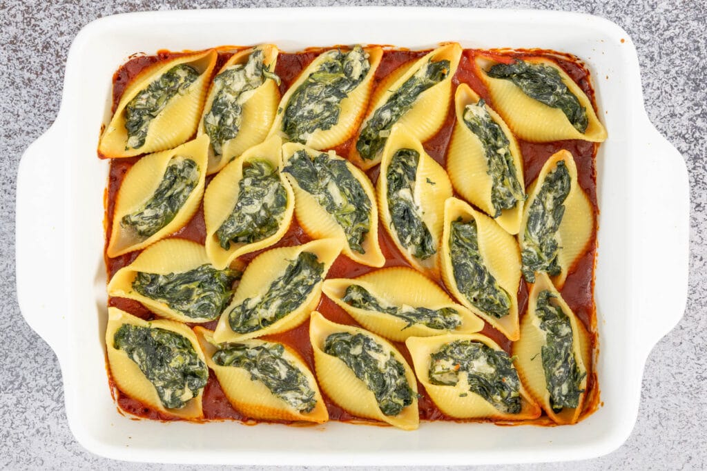 Vegane gefüllte Pasta mit Spinat und veganem Frischkäse in Tomatensauce, frisch aus dem Ofen